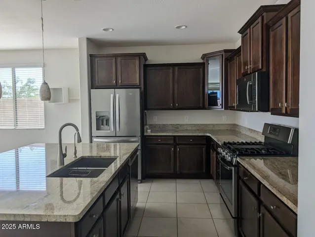 a kitchen with granite countertop a stove sink and cabinets