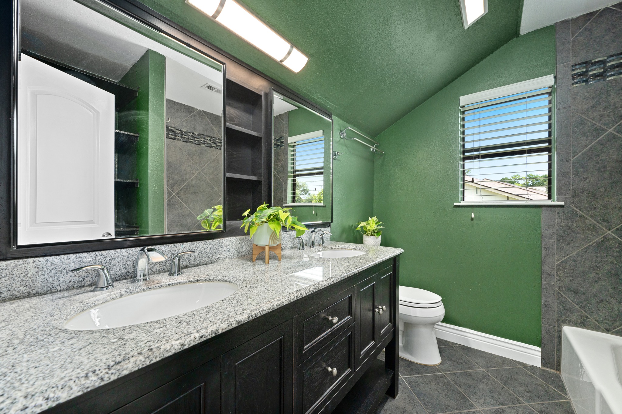 3908 Valley View Round Rock, TX 78681 - Photo 26 of 39 The upstairs full bath features dual sinks, granite counters, dark cabinetry, and a fun pop of color that gives it personality.