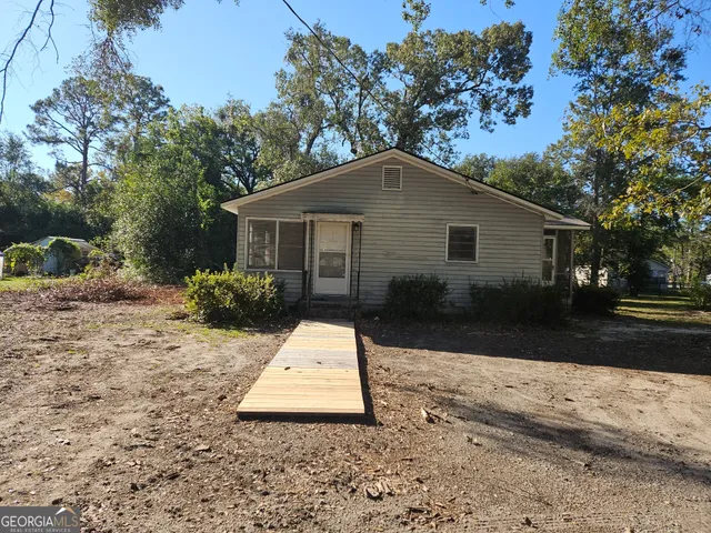 a white house that has a tree in front of it