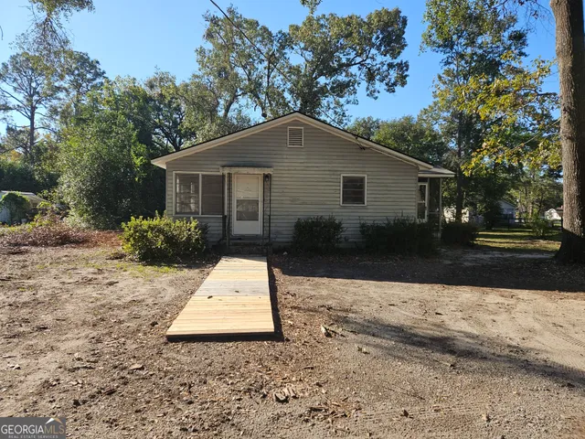 a backyard of a house with a yard and potted plants