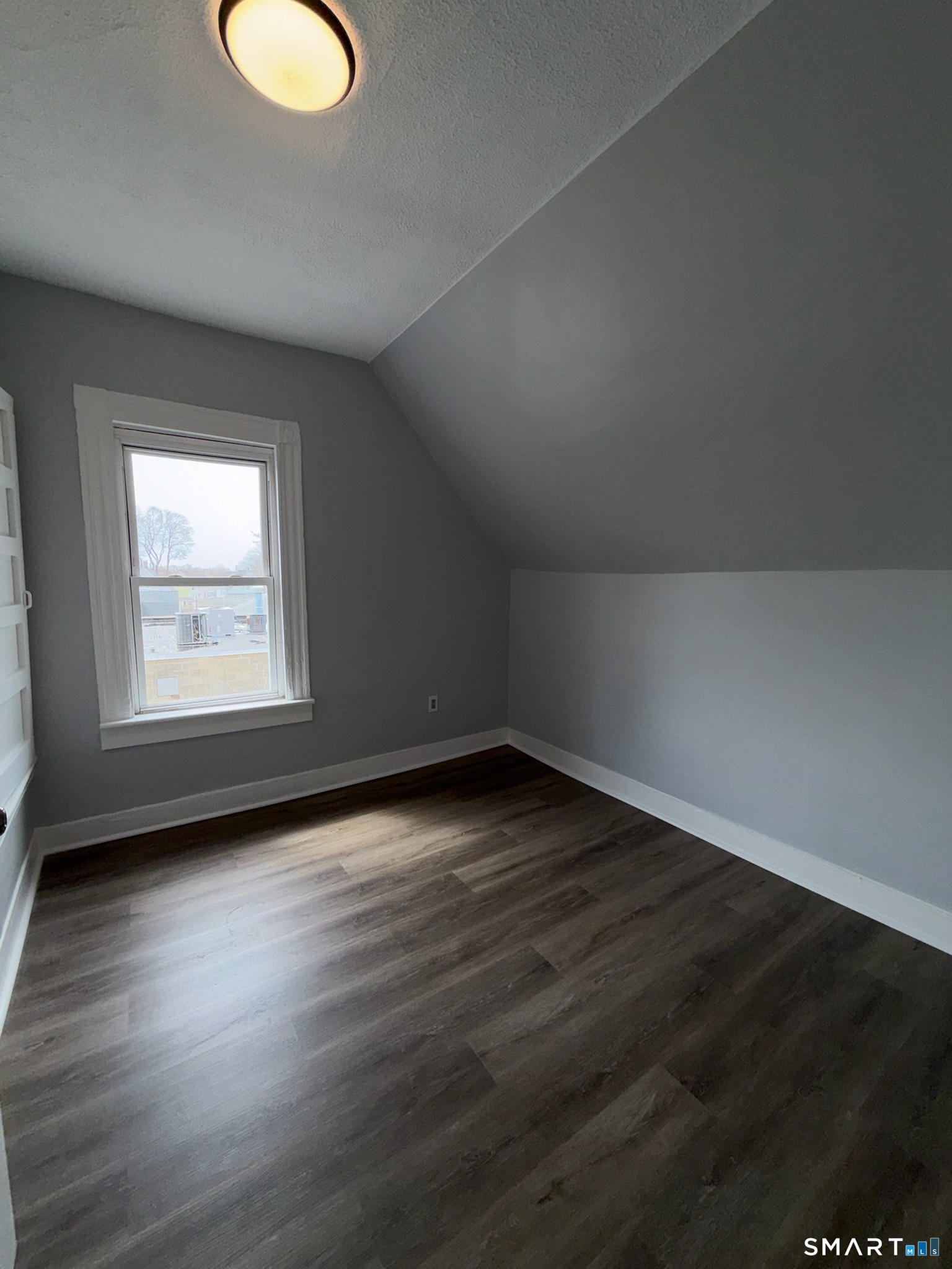 7-9 Wilson Street, Unit 3 Bridgeport, CT 06605 - Photo 12 of 14 an empty room with wooden floor and windows