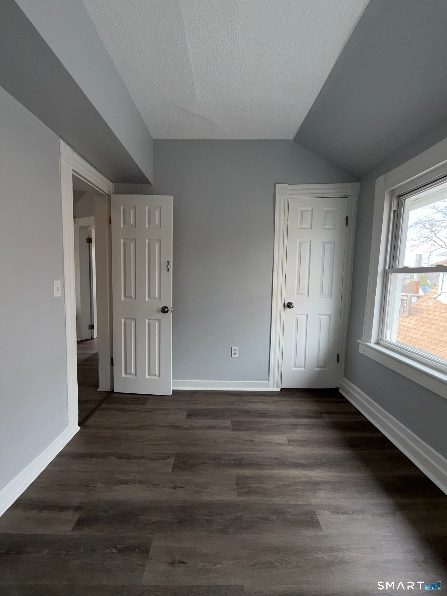 7-9 Wilson Street, Unit 3 Bridgeport, CT 06605 - Photo 13 of 14 a view of an empty room with wooden floor and a window