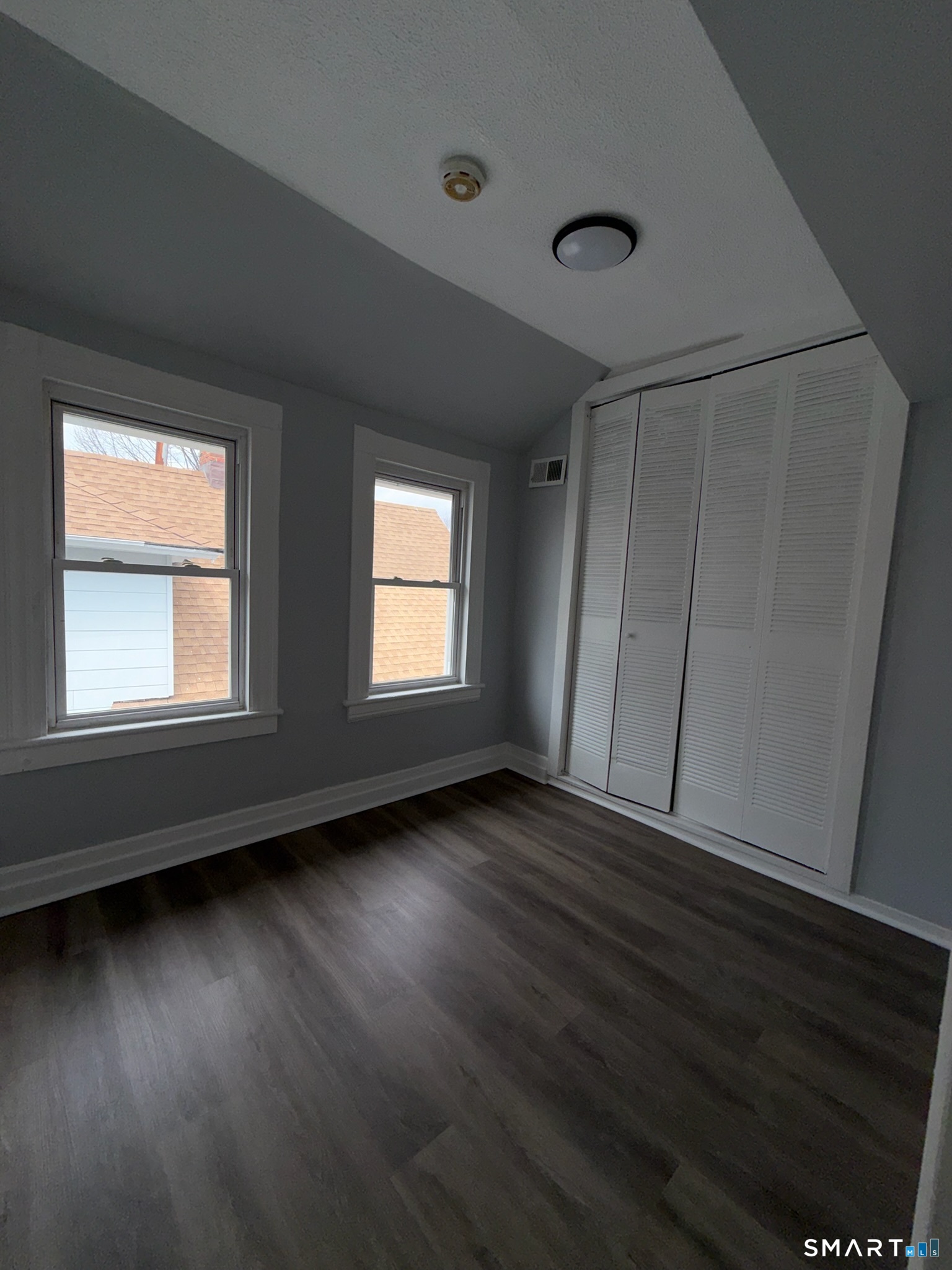 7-9 Wilson Street, Unit 3 Bridgeport, CT 06605 - Photo 14 of 14 an empty room with wooden floor and windows