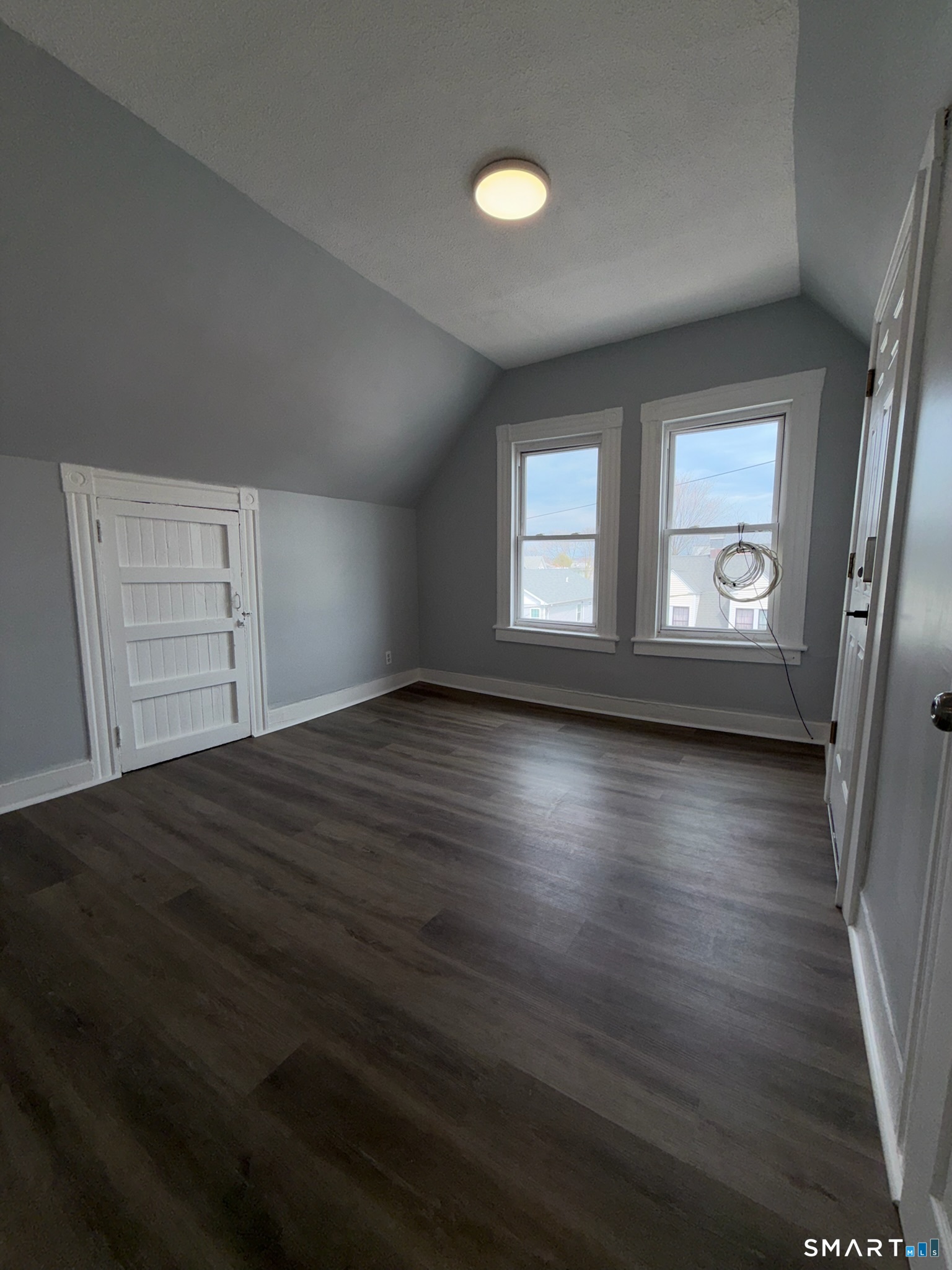 7-9 Wilson Street, Unit 3 Bridgeport, CT 06605 - Photo 4 of 14 an empty room with wooden floor and windows