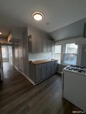 a kitchen with stainless steel appliances a sink window and wooden floor