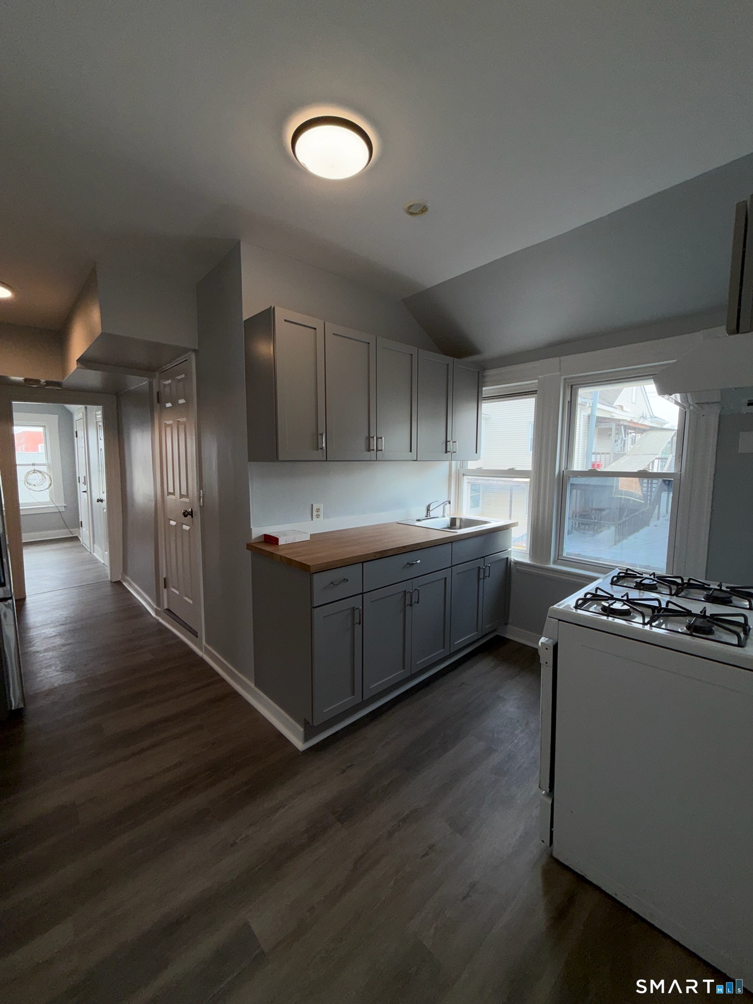 7-9 Wilson Street, Unit 3 Bridgeport, CT 06605 - Photo 8 of 14 a kitchen with stainless steel appliances a sink window and wooden floor
