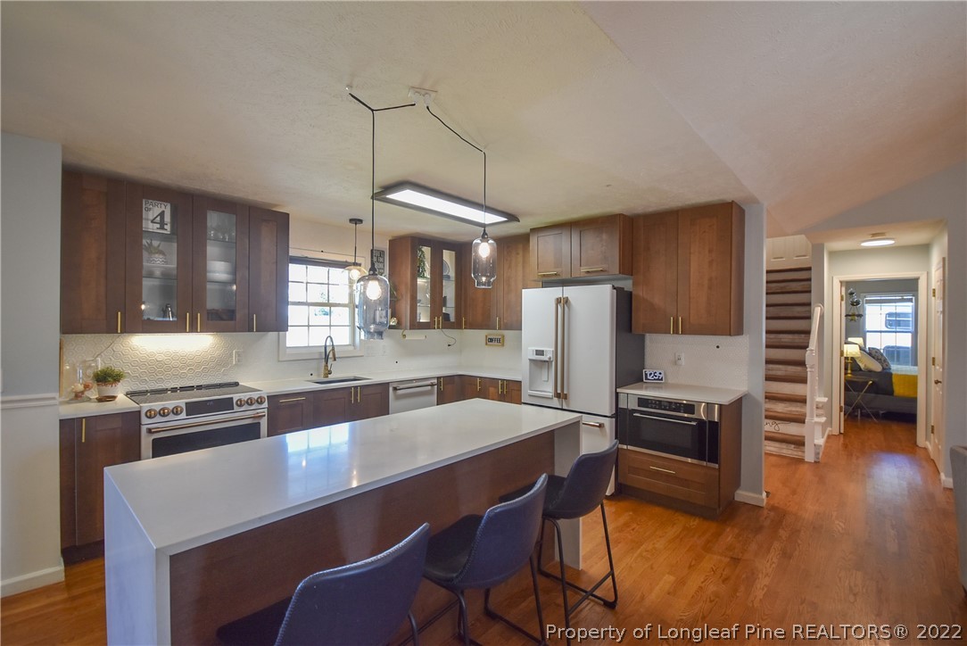 102 Chesapeake Road Cameron, NC 28326 - Photo 11 of 50 a kitchen with stainless steel appliances a dining table chairs stove microwave and refrigerator