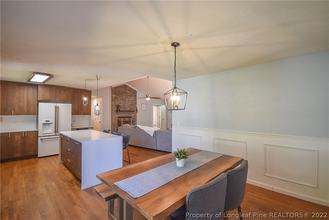 102 Chesapeake Road Cameron, NC 28326 - Photo 15 of 50 a view of a dining room with furniture a chandelier and wooden floor