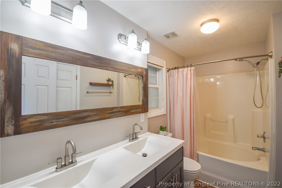 102 Chesapeake Road Cameron, NC 28326 - Photo 19 of 50 a bathroom with a shower sink vanity and mirror