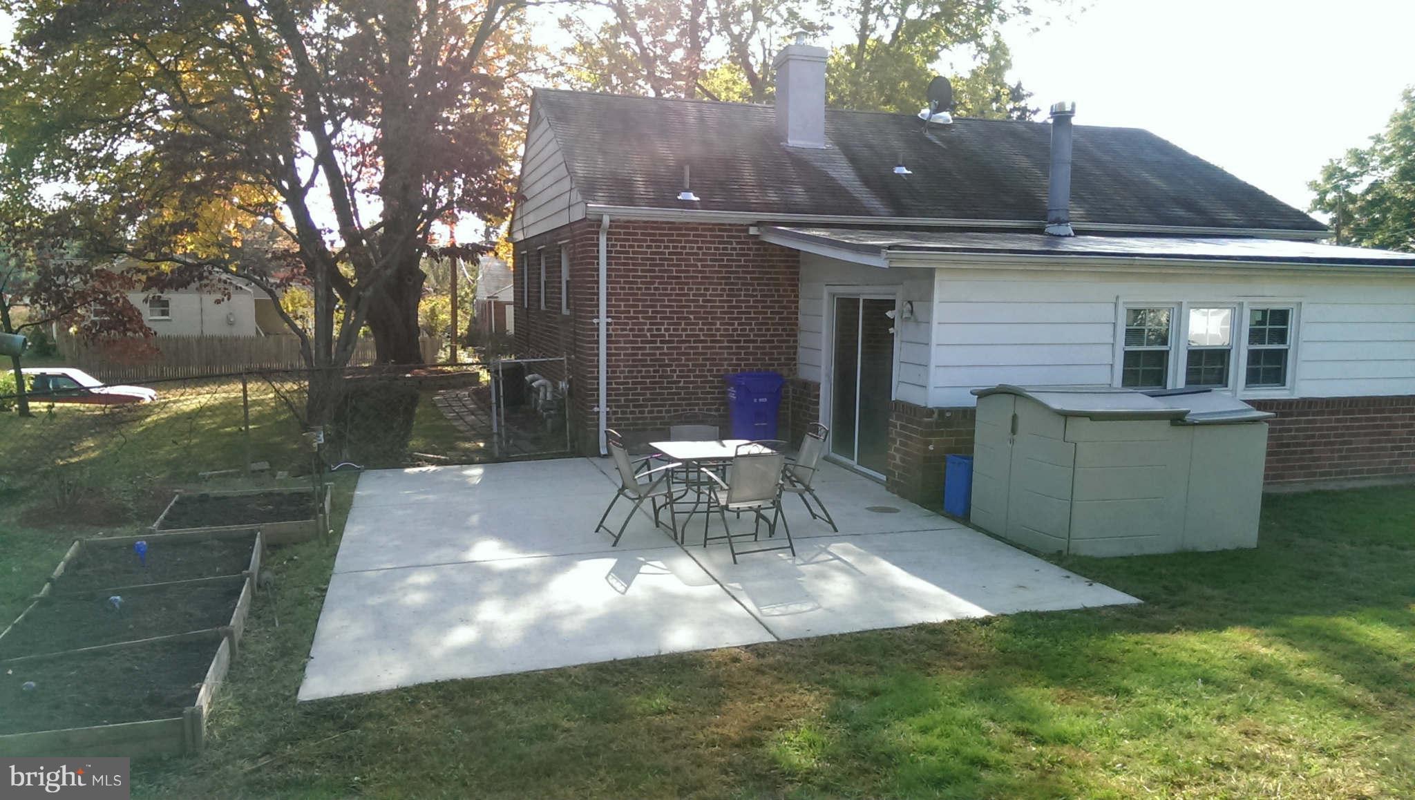 12102 Foley Street Silver Spring, MD 20902 - Photo 27 of 29 a view of a backyard with table and chairs potted plants and large tree