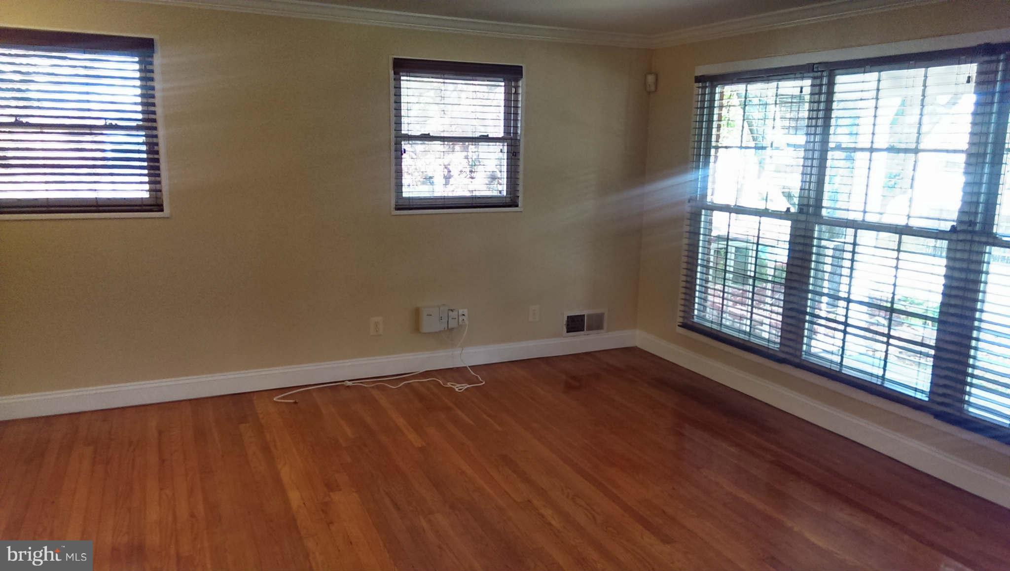 12102 Foley Street Silver Spring, MD 20902 - Photo 4 of 29 a view of an empty room with wooden floor and a window