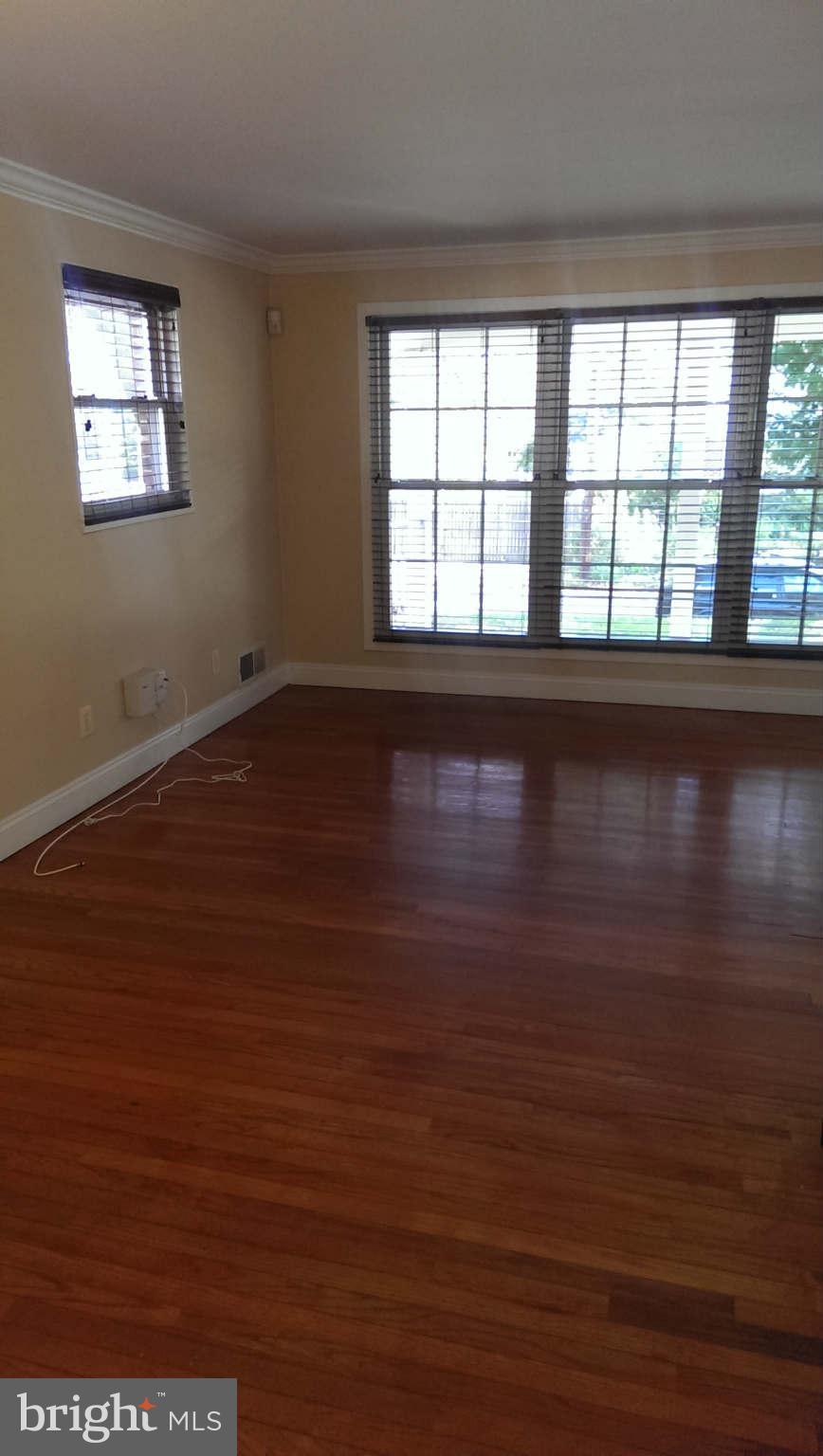 12102 Foley Street Silver Spring, MD 20902 - Photo 5 of 29 wooden floor in an empty room with a window