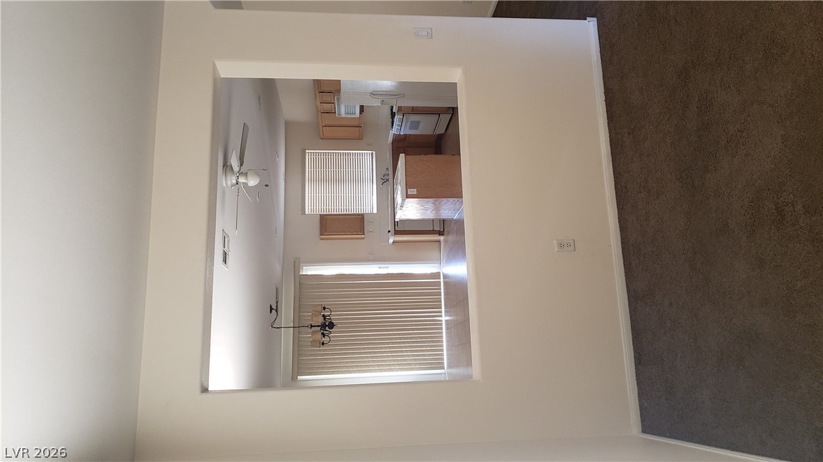 9112 Manalang Road Las Vegas, NV 89123 - Photo 27 of 50 An open pass-through window connects the living space to a kitchen featuring an island and appliances.