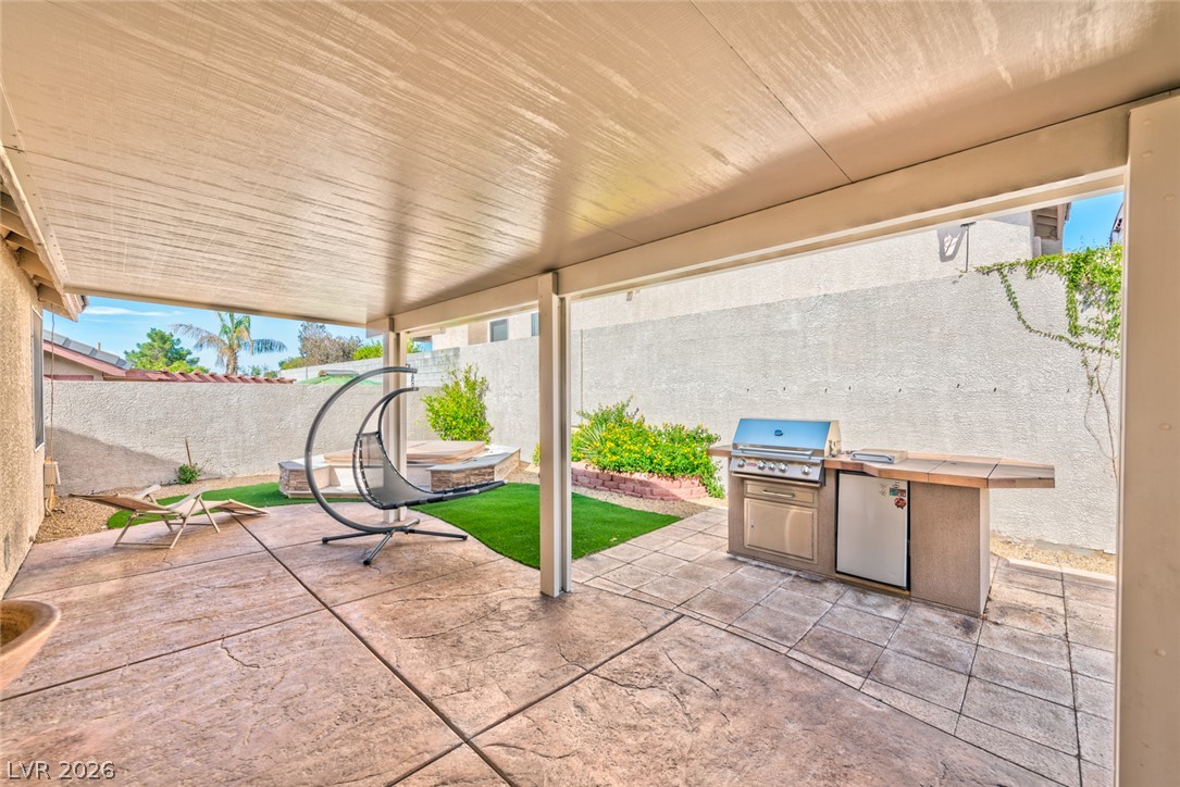 84 Milicity Road Henderson, NV 89012 - Photo 4 of 16 An inviting covered patio features a built-in outdoor kitchen ideal for entertaining.