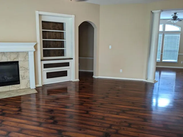 a view of a living room with wooden floor and fireplace