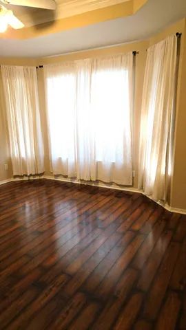 an empty room with wooden floor and a window