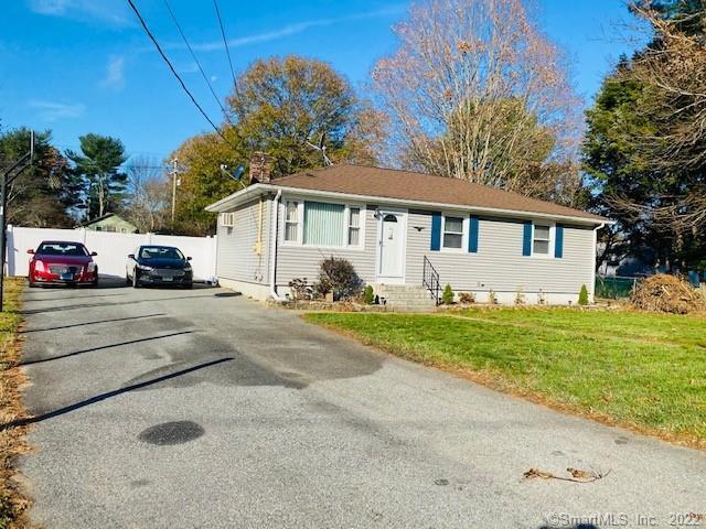 a view of a white house next to a yard and road