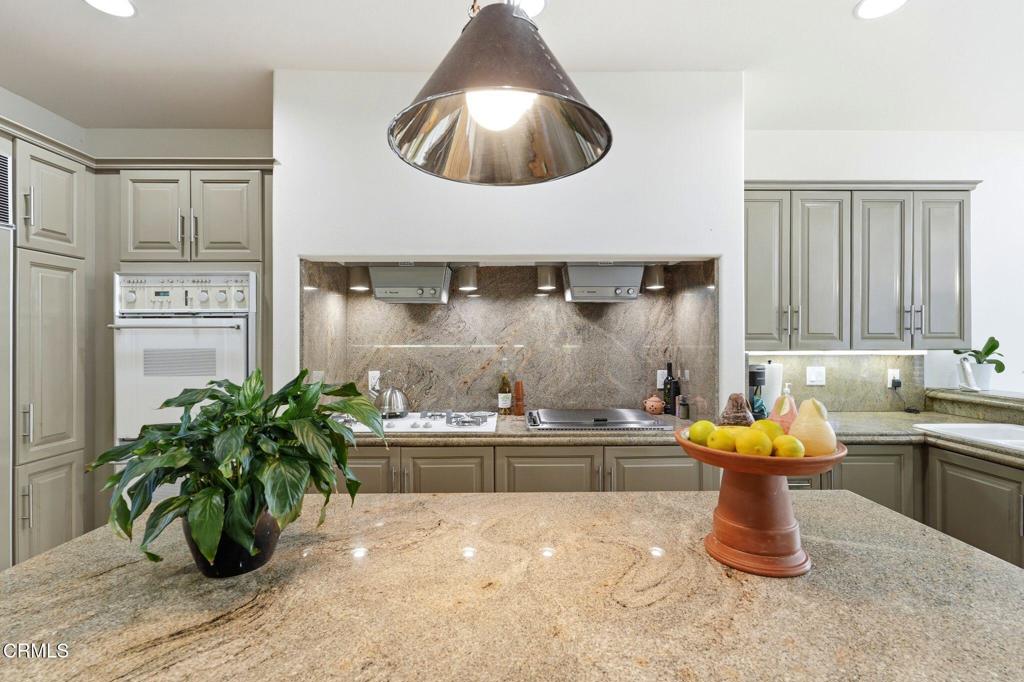 2317 Canyonback Road Los Angeles, CA 90049 - Photo 14 of 72 a kitchen with stainless steel appliances kitchen island granite countertop a sink a stove and a wooden floors