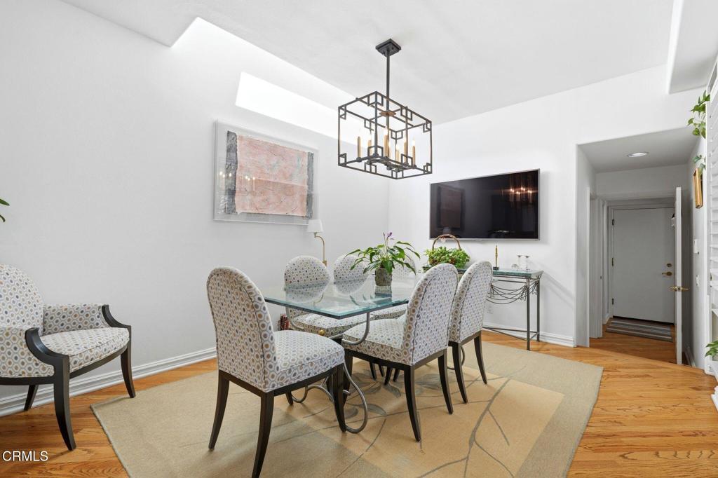 2317 Canyonback Road Los Angeles, CA 90049 - Photo 17 of 72 a view of a dining room with furniture a chandelier and wooden floor