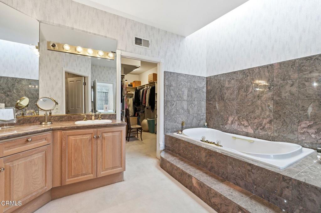 2317 Canyonback Road Los Angeles, CA 90049 - Photo 32 of 72 a spacious bathroom with a tub a double vanity sink and a mirror