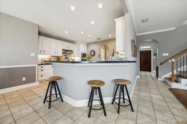 a kitchen with stainless steel appliances kitchen island granite countertop a sink a stove a refrigerator and cabinets