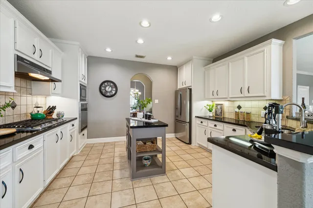 a kitchen with stainless steel appliances kitchen island granite countertop a sink and cabinets