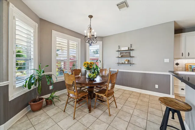 a view of a dining room with furniture and a chandelier