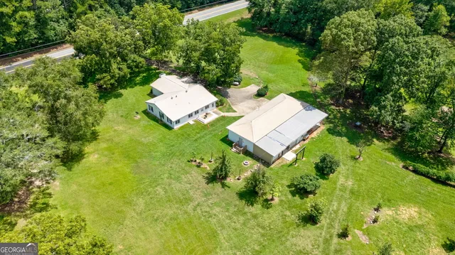 an aerial view of a house with swimming pool and garden