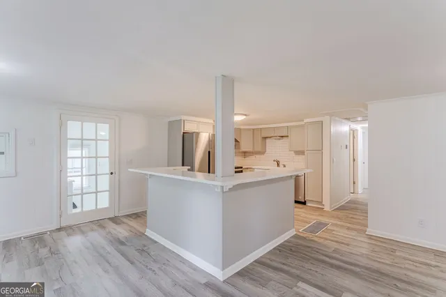 a view of kitchen with stainless steel appliances a stove top oven and cabinets