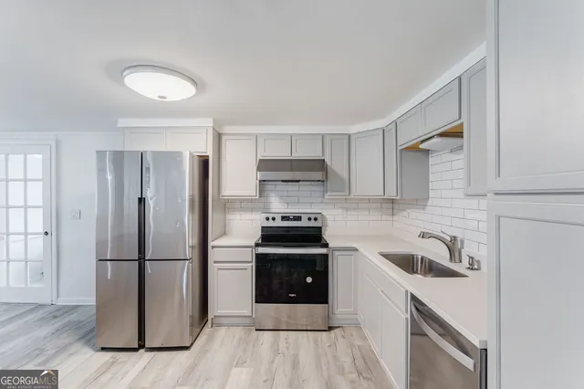 a kitchen with a sink stove and refrigerator
