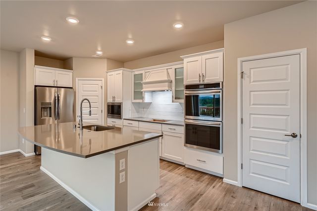a kitchen with kitchen island granite countertop a stove and a refrigerator