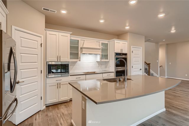 a kitchen with stainless steel appliances a microwave sink and cabinets