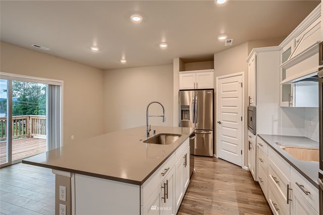 a kitchen with kitchen island granite countertop a sink stove and refrigerator
