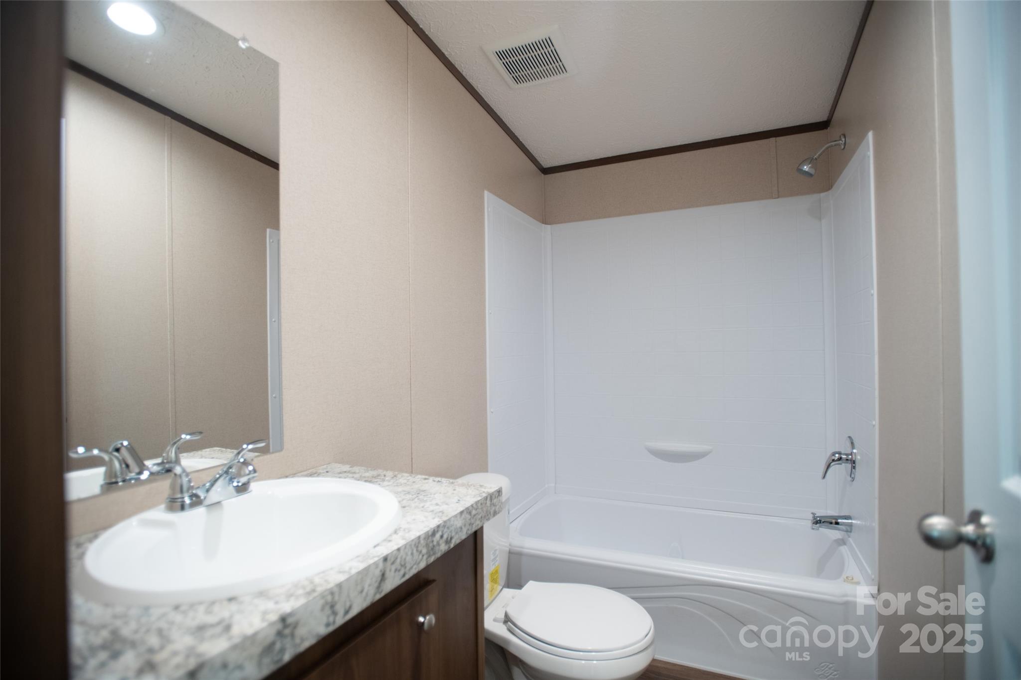 1455 Newfound Road Leicester, NC 28748 - Photo 18 of 47 a bathroom with a granite countertop sink toilet and shower