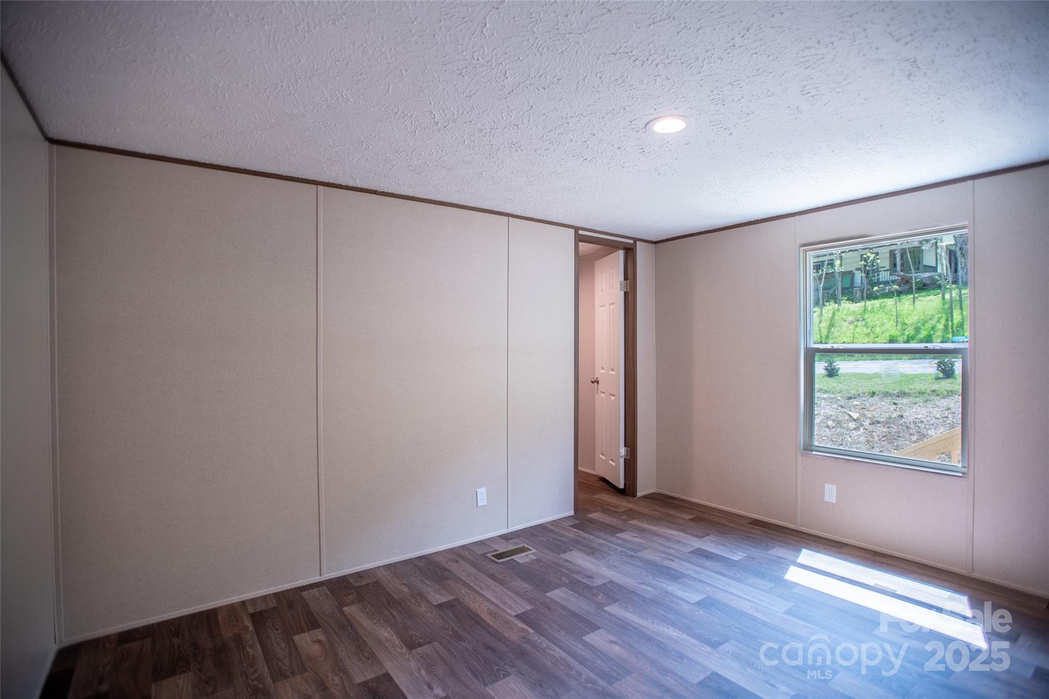 1455 Newfound Road Leicester, NC 28748 - Photo 21 of 47 an empty room with wooden floor and windows