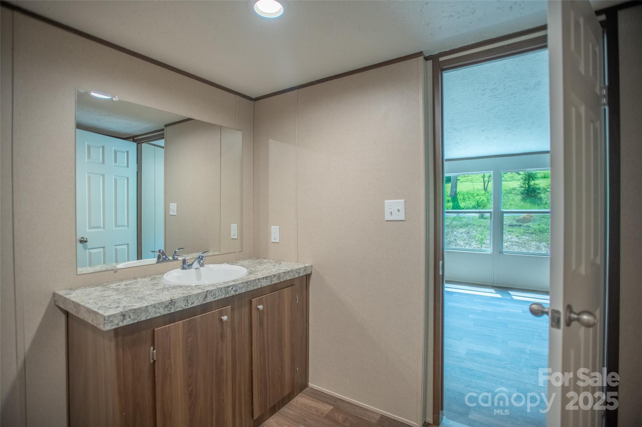 1455 Newfound Road Leicester, NC 28748 - Photo 28 of 47 a bathroom with a granite countertop sink and a mirror