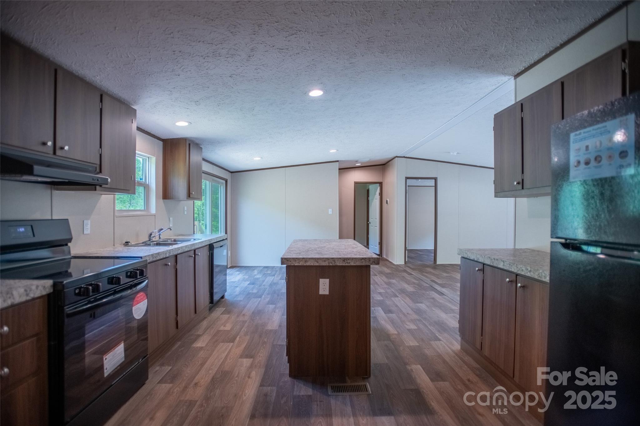 1455 Newfound Road Leicester, NC 28748 - Photo 6 of 47 a kitchen with stainless steel appliances granite countertop a stove a sink and a refrigerator