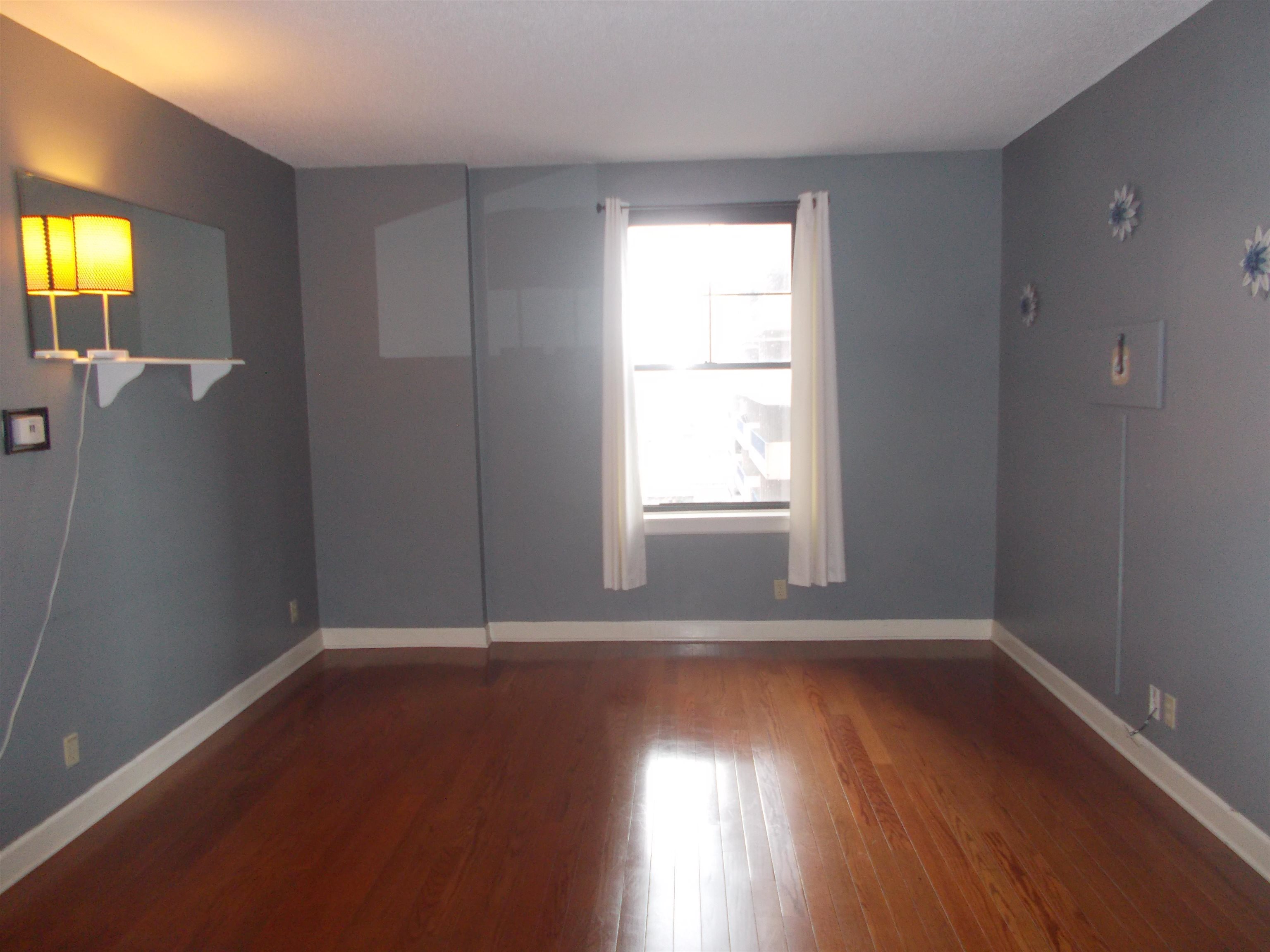 109 North Main Street, Unit 1207 Memphis, TN 38103 - Photo 3 of 25 Unfurnished room featuring baseboards and dark wood-style floors