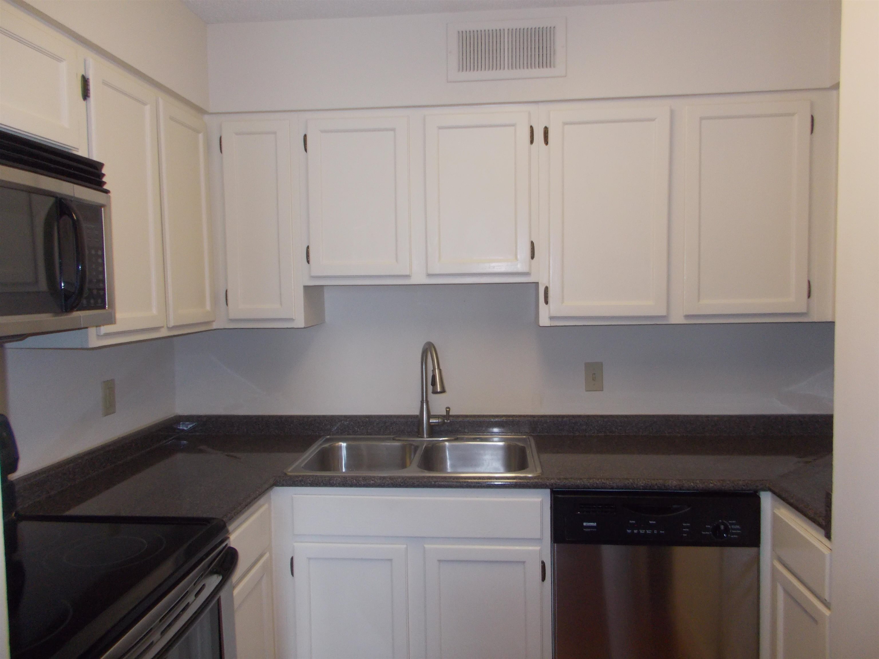 109 North Main Street, Unit 1207 Memphis, TN 38103 - Photo 9 of 25 Kitchen featuring appliances with stainless steel finishes, white cabinetry, and dark countertops