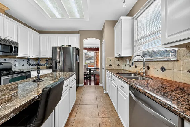 a kitchen with granite countertop a sink and a stove