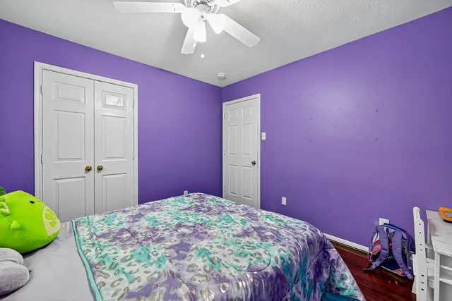 a bedroom with a bed a chandelier and pink walls