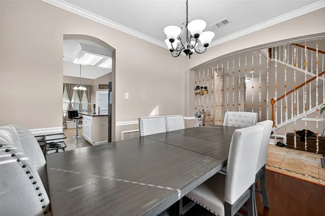 a view of a dining room with furniture and chandelier