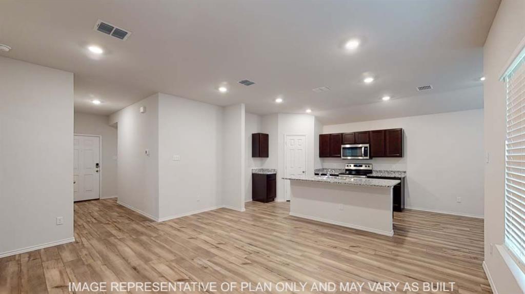 10428 Neptune Court Waco, TX 76708 - Photo 3 of 12 Open-concept living space with wood-finish flooring, recessed lighting, and a kitchen island featuring a light-toned countertop