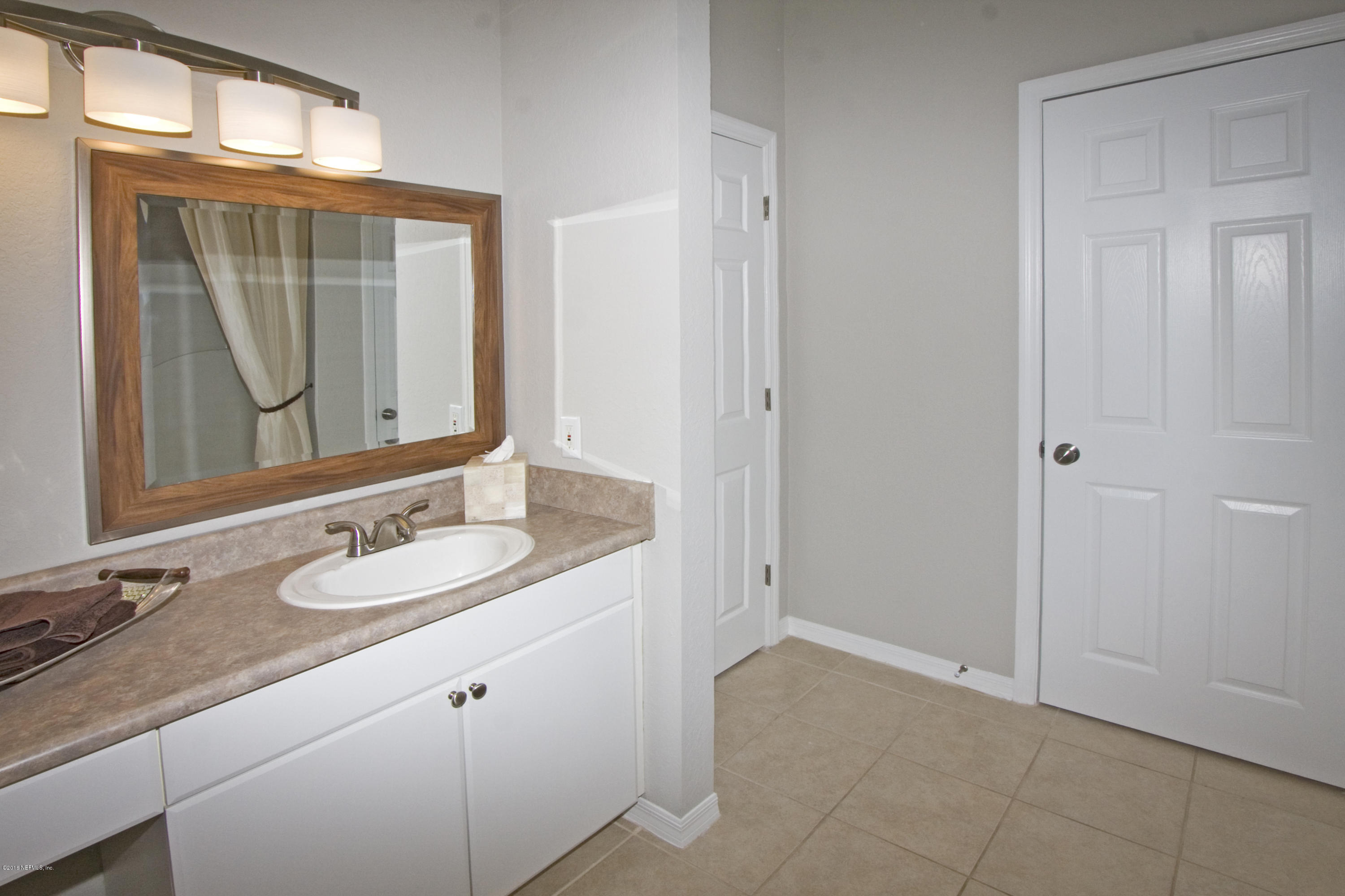 10961 Burnt Mill Road, Unit 222 Jacksonville, FL 32256 - Photo 11 of 20 a bathroom with a granite countertop sink and a mirror