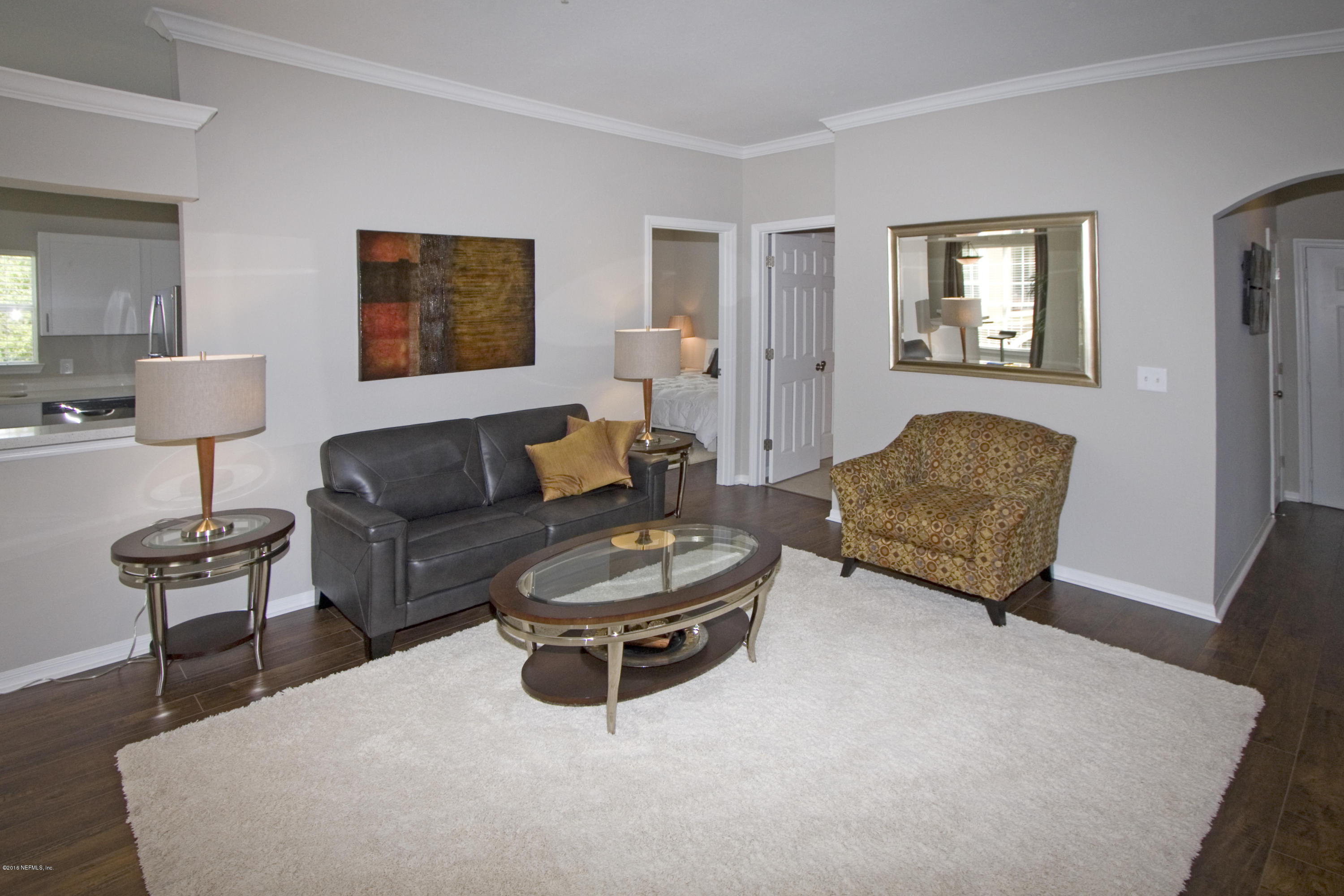 10961 Burnt Mill Road, Unit 222 Jacksonville, FL 32256 - Photo 6 of 20 a living room with furniture a rug and a painting