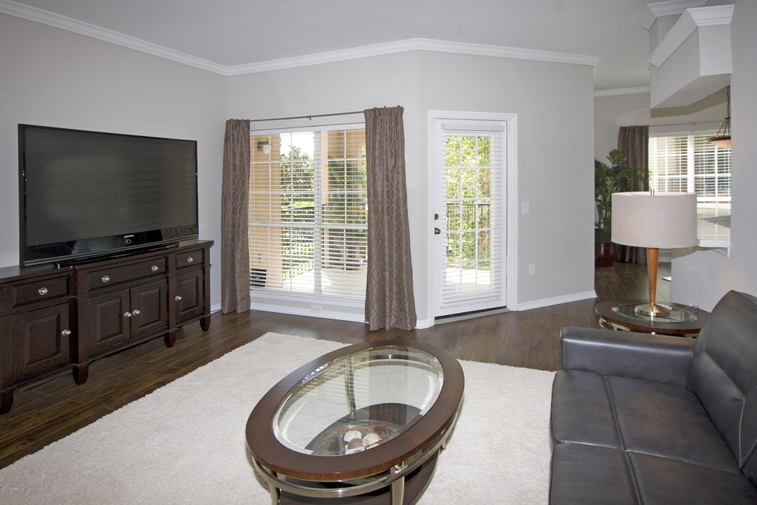 10961 Burnt Mill Road, Unit 222 Jacksonville, FL 32256 - Photo 9 of 20 a living room with furniture and a flat screen tv