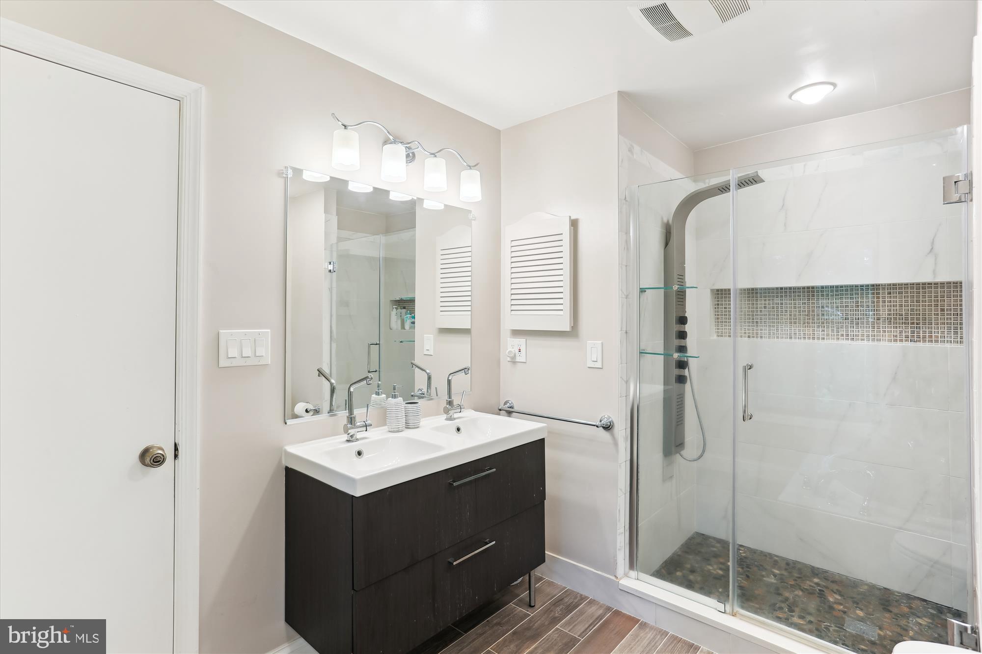 4 Eaglebrook Court Rockville, MD 20854 - Photo 39 of 83 a bathroom with a double vanity sink mirror and shower