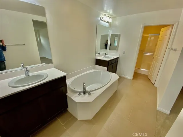 a bathroom with a sink a tub and a mirror