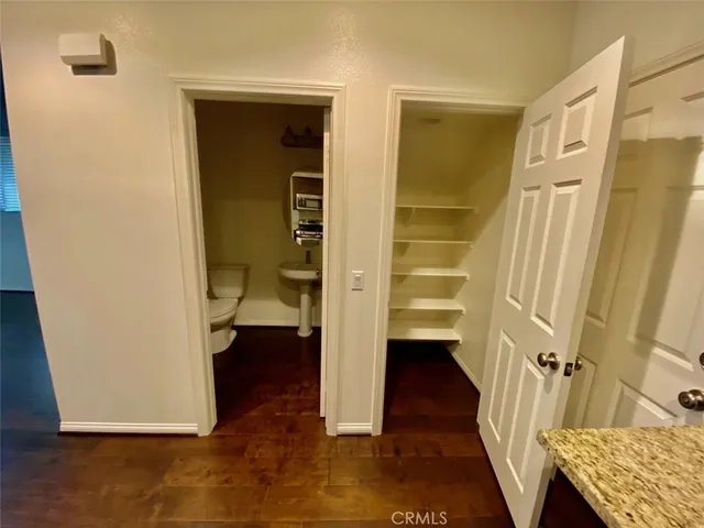 a view of walk in closet with wooden floor