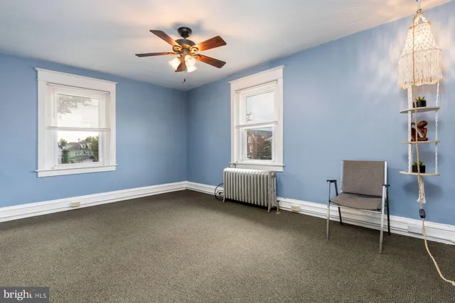 an empty room with a window and a ceiling fan